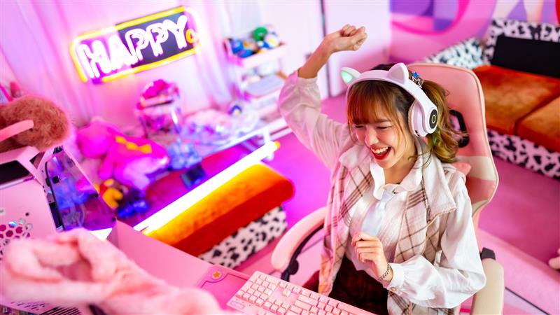 Young Asian woman esports gamer playing an online game on her computer in the bedroom