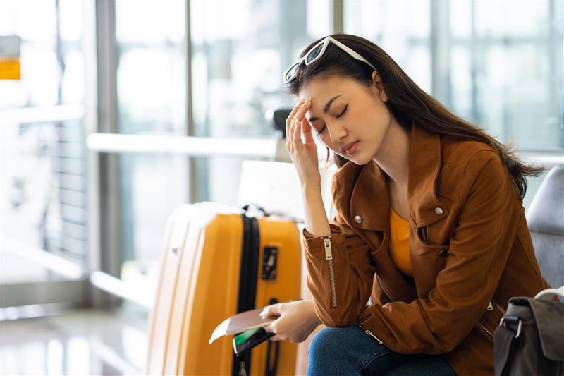 Tired young female traveler waiting at the airport
