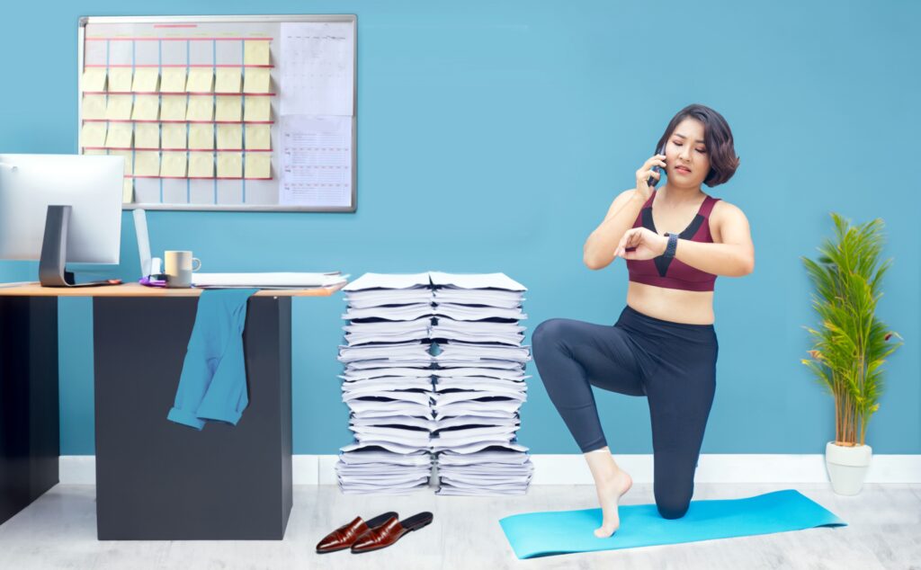 Asian woman doing yoga at the office as part of her daily routine